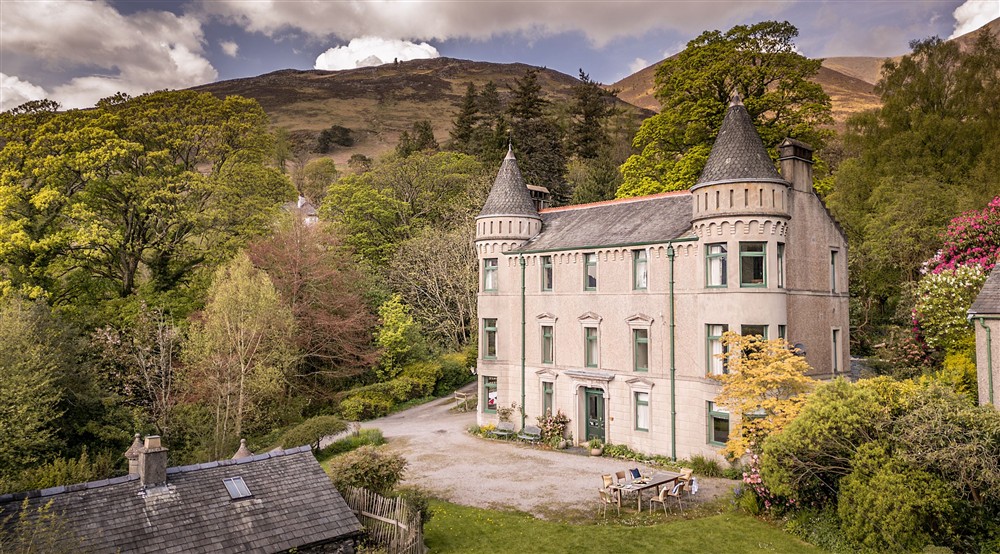 An aerial view of the front of Millbeck Towers, with Skiddaw in the background, Cumbria at Millbeck Towers in Keswick, Cumbria