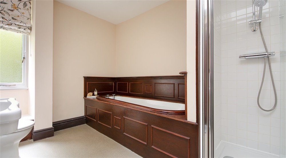 The bathroom with freestanding bath and walk-in shower on the second floor at Millbeck Towers in Keswick, Cumbria