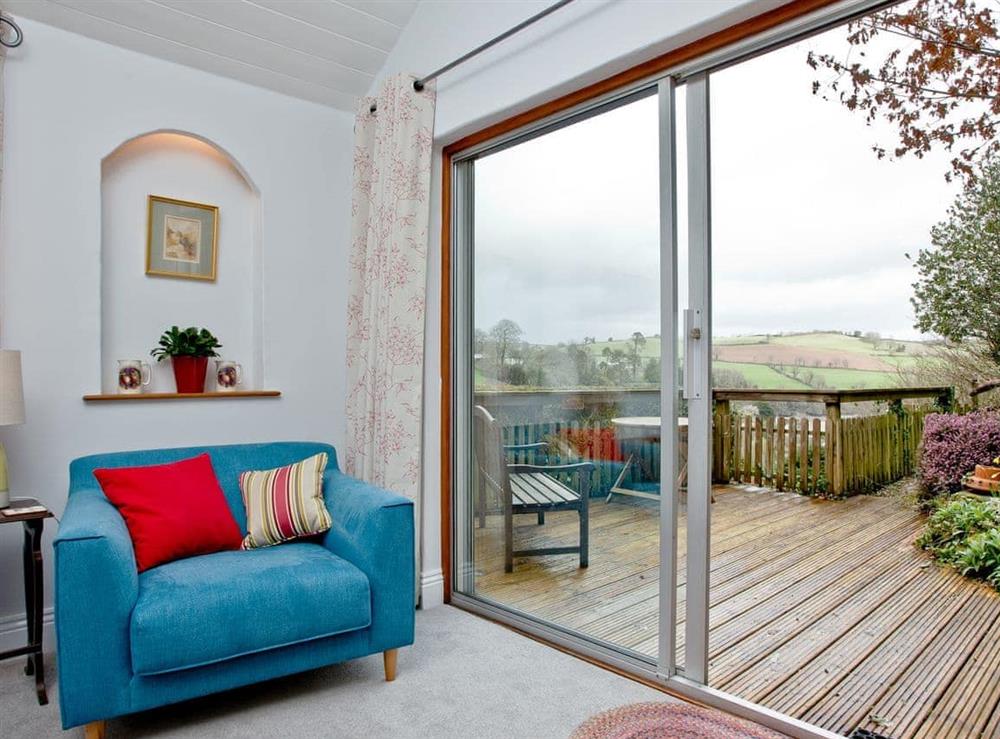 Living area with doors to garden at Miller’s Thumb in Bow Creek, Nr Totnes, South Devon., Great Britain