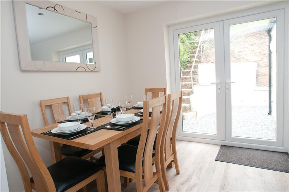 Open plan dining and kitchen area with doors leading out  to the garden at Miloran in , Salcombe