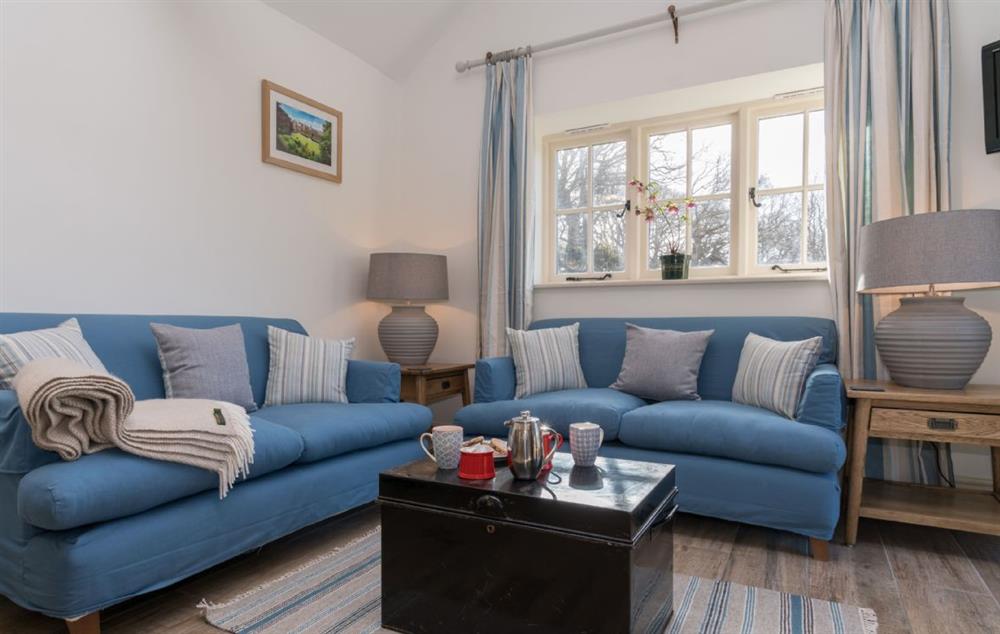Sitting room with comfortable sofas and lots of natural light at Minafon, Colwyn Bay