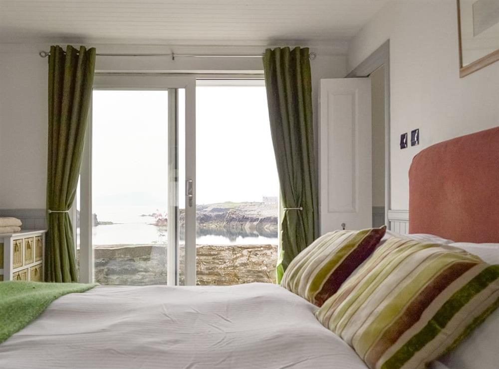 Comfortable en-suite double bedroom with sliding door to patio at Misty Isles Cottage in Oban, Argyll