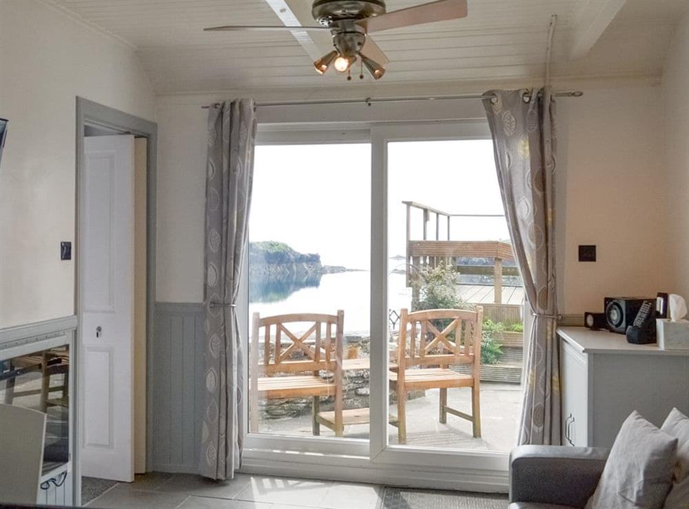 Open-plan living area with sliding door to patio area at Misty Isles Cottage in Oban, Argyll