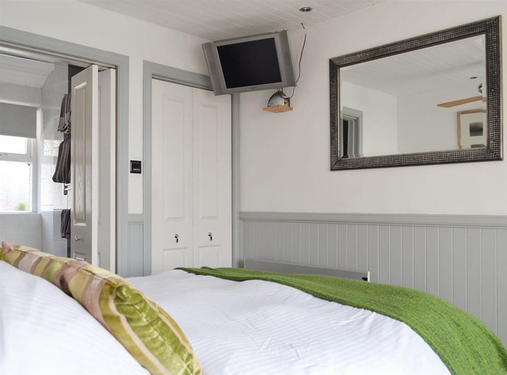 Peaceful en-suite double bedroom with wall-mounted TV at Misty Isles Cottage in Oban, Argyll