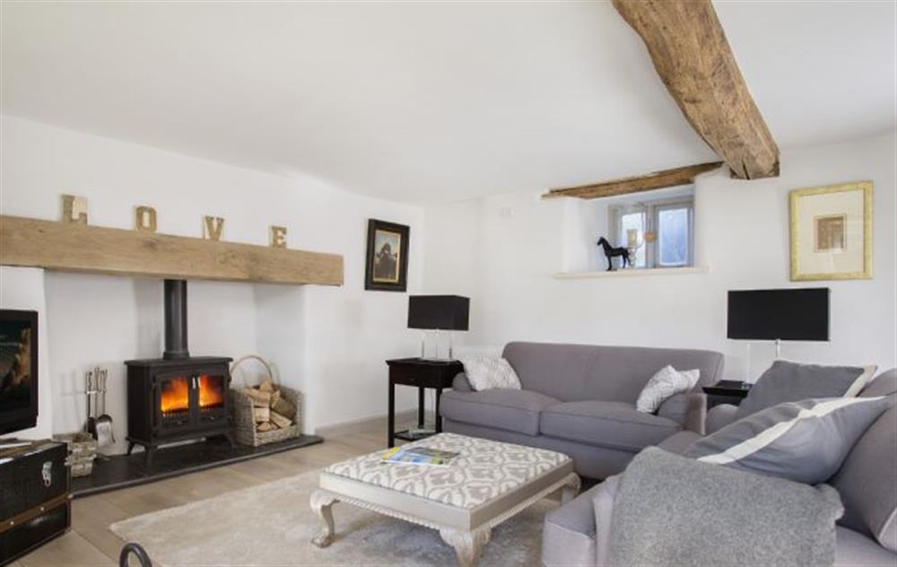 Sitting room with inglenook fireplace and wood burning stove at Mole End Cottage, North Cerney
