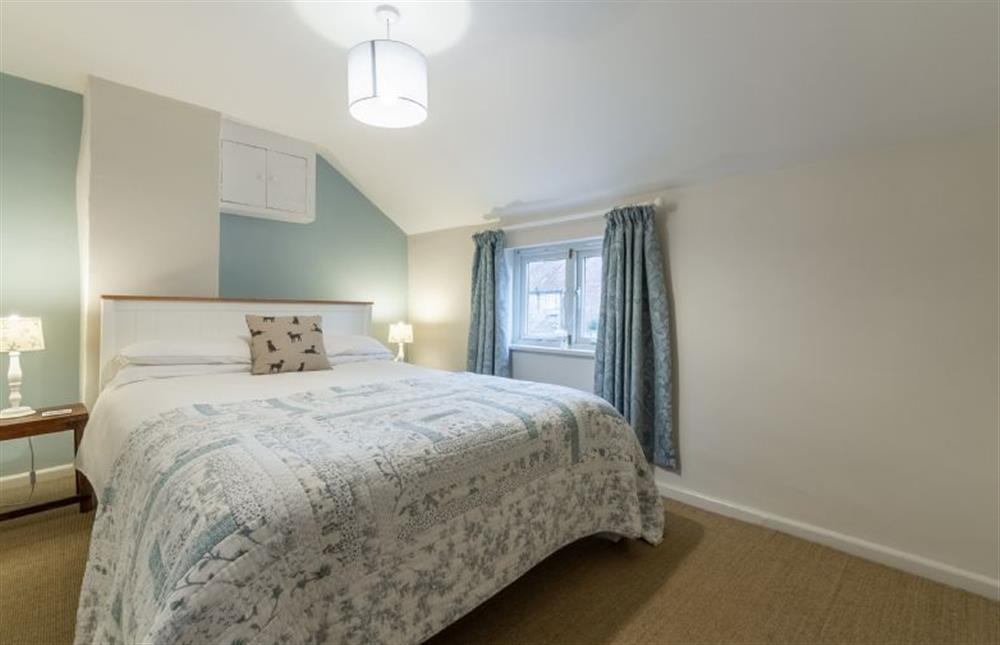First floor:  Master bedroom with king-size bed and window at Montgomery Cottage, Docking near Kings Lynn