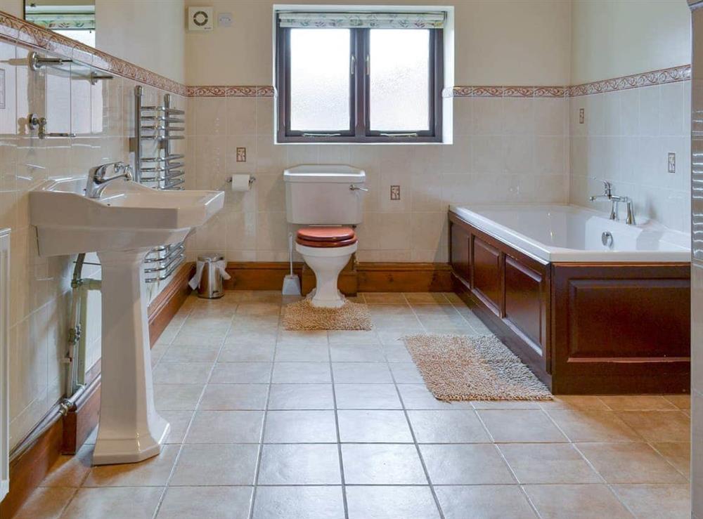 Family bathroom with bath and separate shower cubicle at Baileys Barn, 