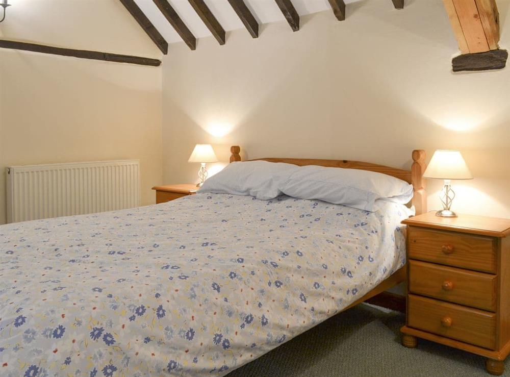 Family bedroom with a double and twin beds at The Old Workshop, 