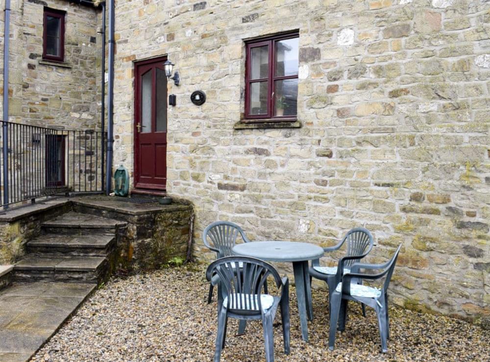 Pebbled courtyard with sitting-out area and garden furniture at Moordale Cottage in Reeth, near Richmond, North Yorkshire
