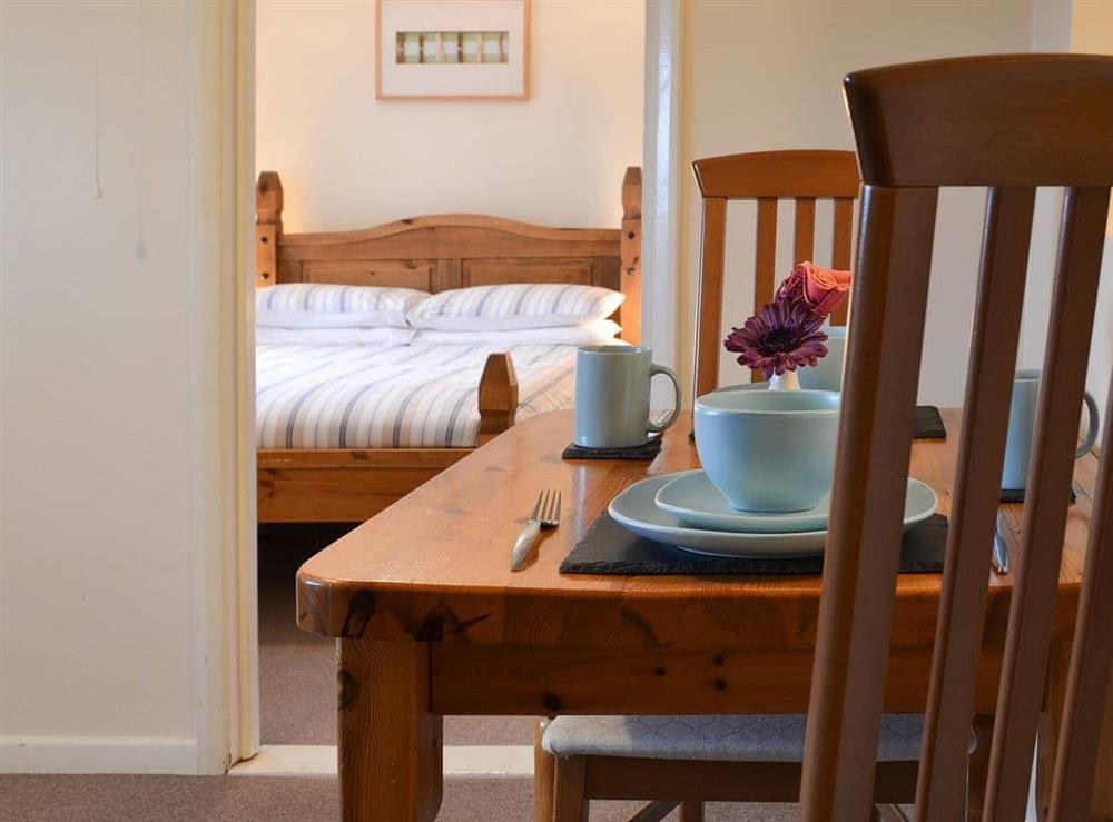 Modest dining area and double bedroom beyond at Bramling, 