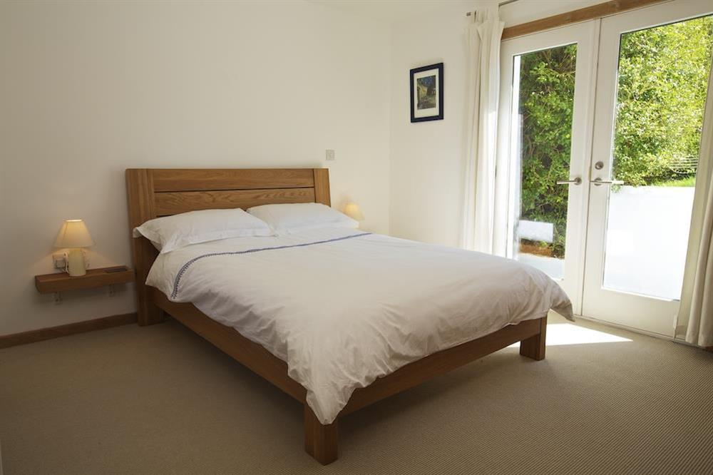 Double bedroom with doors to the garden at Moorings in East Portlem'th, Salcombe