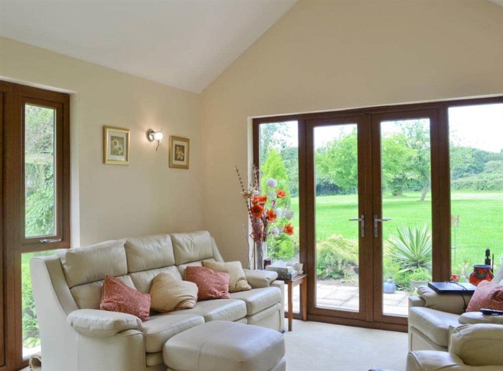 Sets of doors lead to impressive garden from the living area at Moorland Lodge in Holt Wood, near Wimborne, Dorset