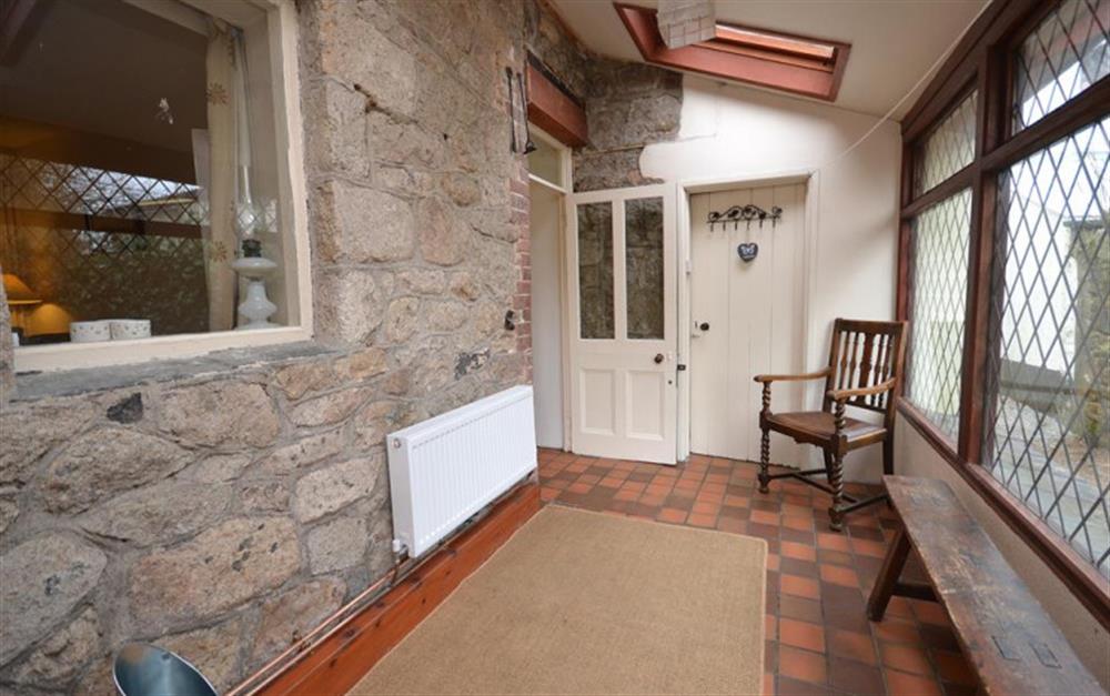 The porch is an ideal spot from which to watch all the garden birds. at Moorlands Cottage in Belstone