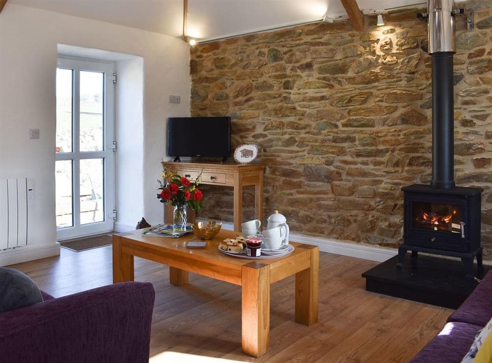 Warm and welcoming living area with woodburner at Bull Pen, 