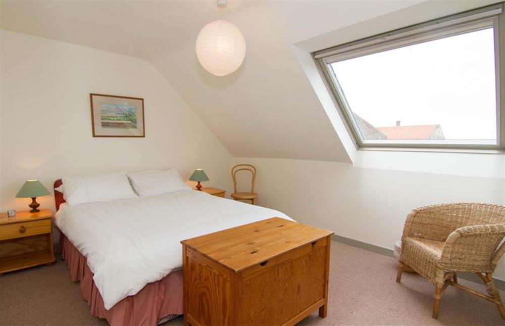 First floor: Master bedroom, with double bed and views to the marsh and harbour at Mow Creek Cottage, Brancaster Staithe near Kings Lynn
