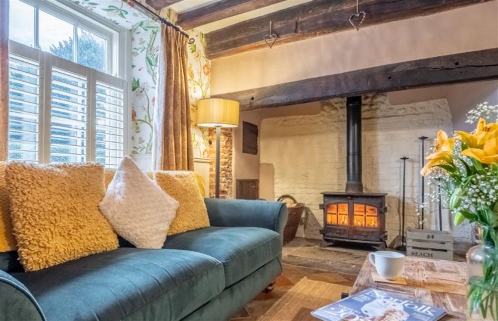 Cosy sitting room with Inglenook fireplace at Mulberry Cottage, Holt