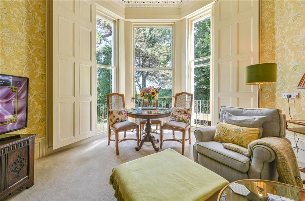 The sitting room with original wooden shutters and bay windows