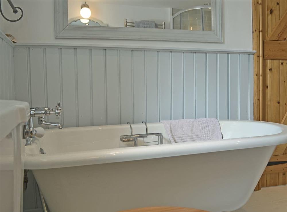 Bathroom featuring an impressive roll-top bath, shower cubicle and toilet at Mur Llwyd in Rhoshirwaun, near Pwllheli, Gwynedd