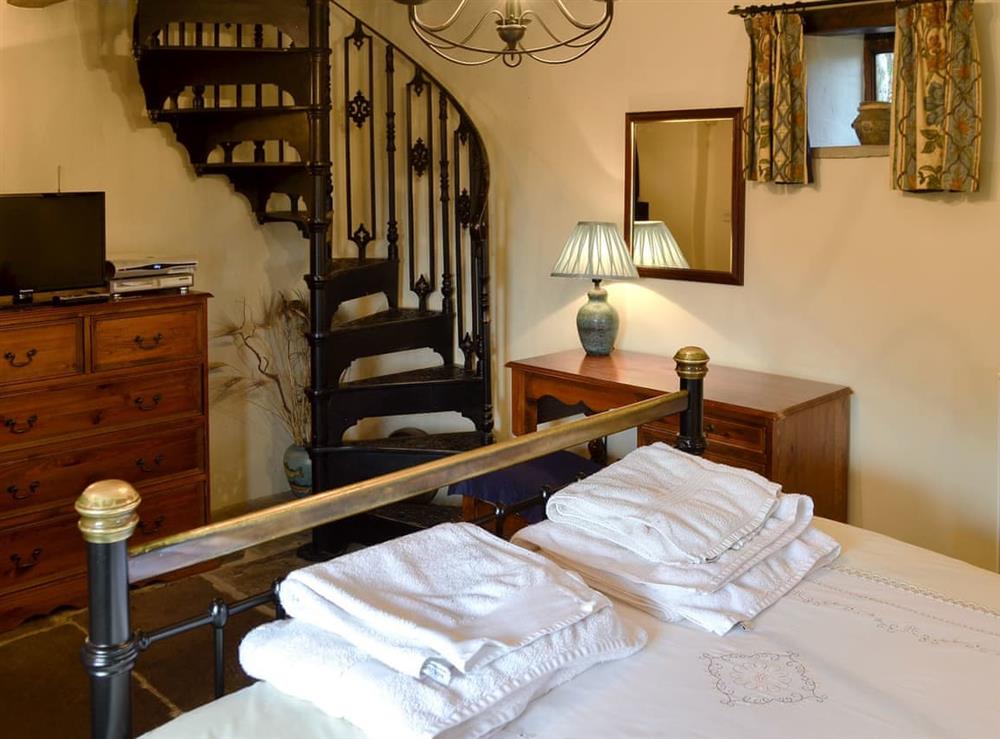 Comfy double bedroom with spiral staircase at Mushroom Cottage in Hope Valley, South Yorkshire