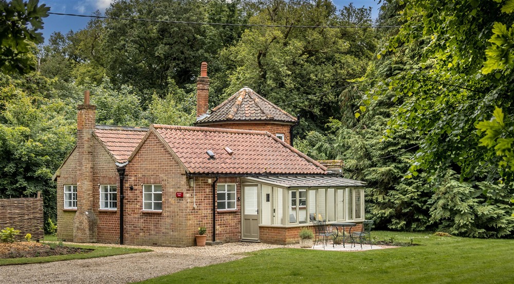 The exterior and garden of Mustard Pot Cottage, surrounded by trees, Norfolk at Mustard Pot Cottage in Norwich, Norfolk