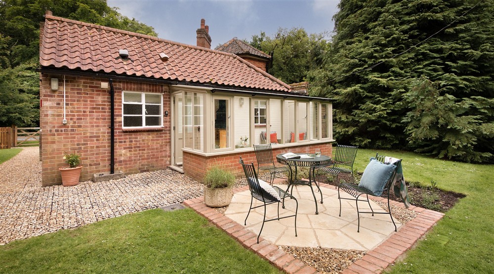 The patio with outdoor dining furniture in the garden at Mustard Pot Cottage in Norwich, Norfolk