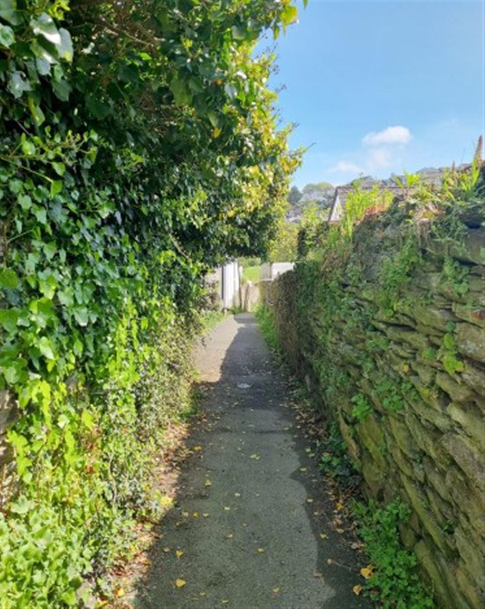 The alleyway and hill leading from the closest public long stay car park to the cottage. The cottage is located off an alleyway which leads down to a park in one direction and the high street in the other direction.