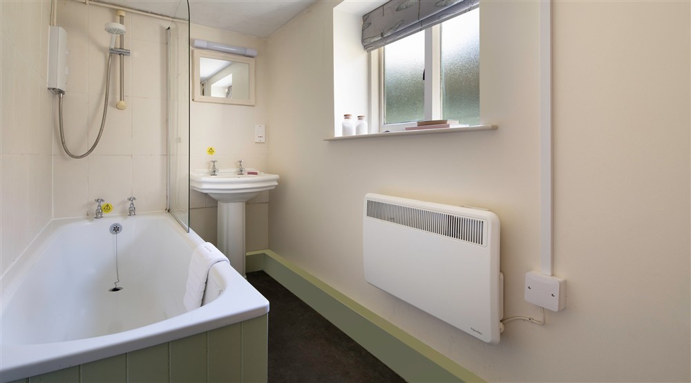 The bathroom with a shower over the bath at Nant Las in Dolgellau, Gwynedd
