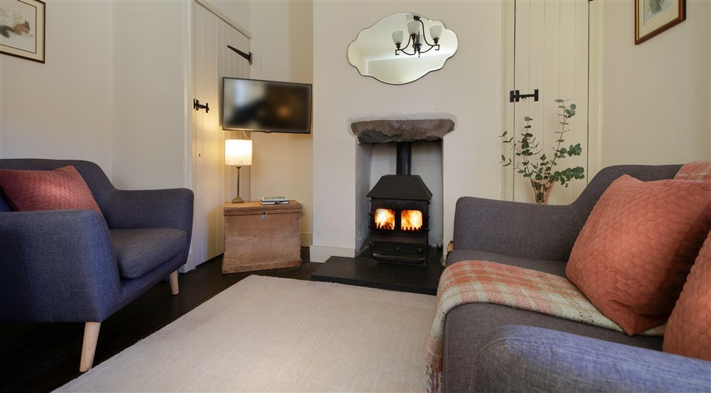 The sitting room with comfortable places to sit by the woodburning stove, Nant Las, Gwynedd at Nant Las in Dolgellau, Gwynedd