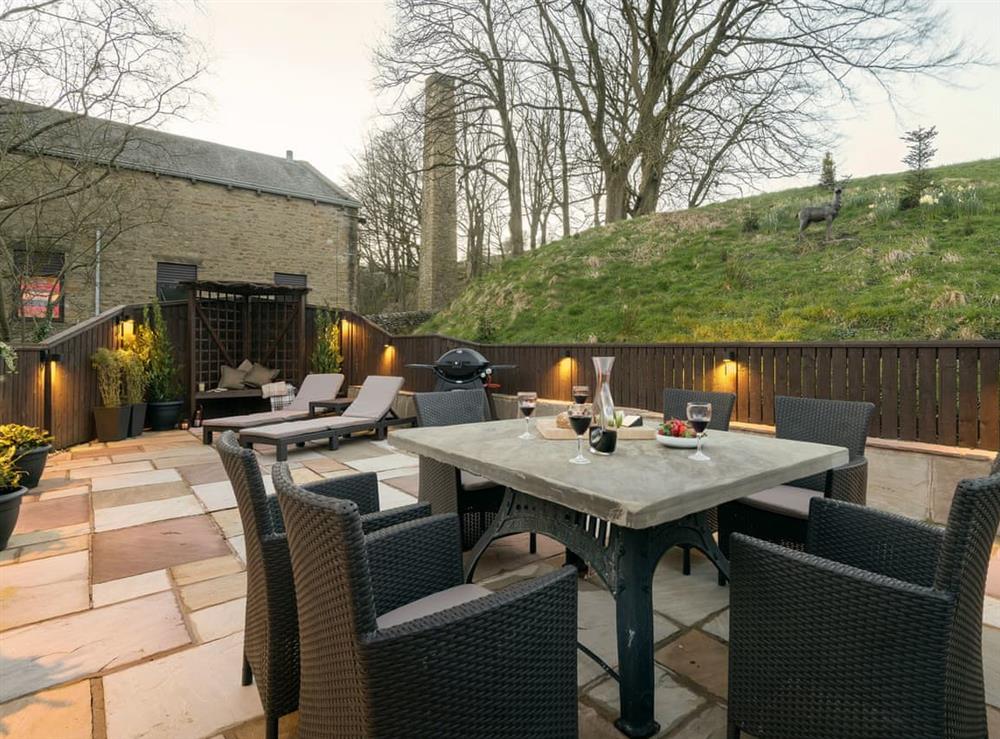 Outdoor eating area of the patio with evening illumination at Narrowgates Cottage in Barley, near Barrowford, Lancashire, England