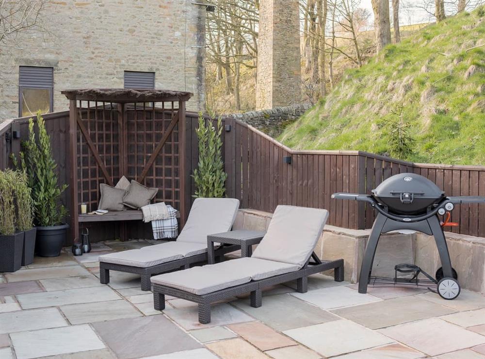 Paved patio with a range of seating options and a BBQ at Narrowgates Cottage in Barley, near Barrowford, Lancashire, England