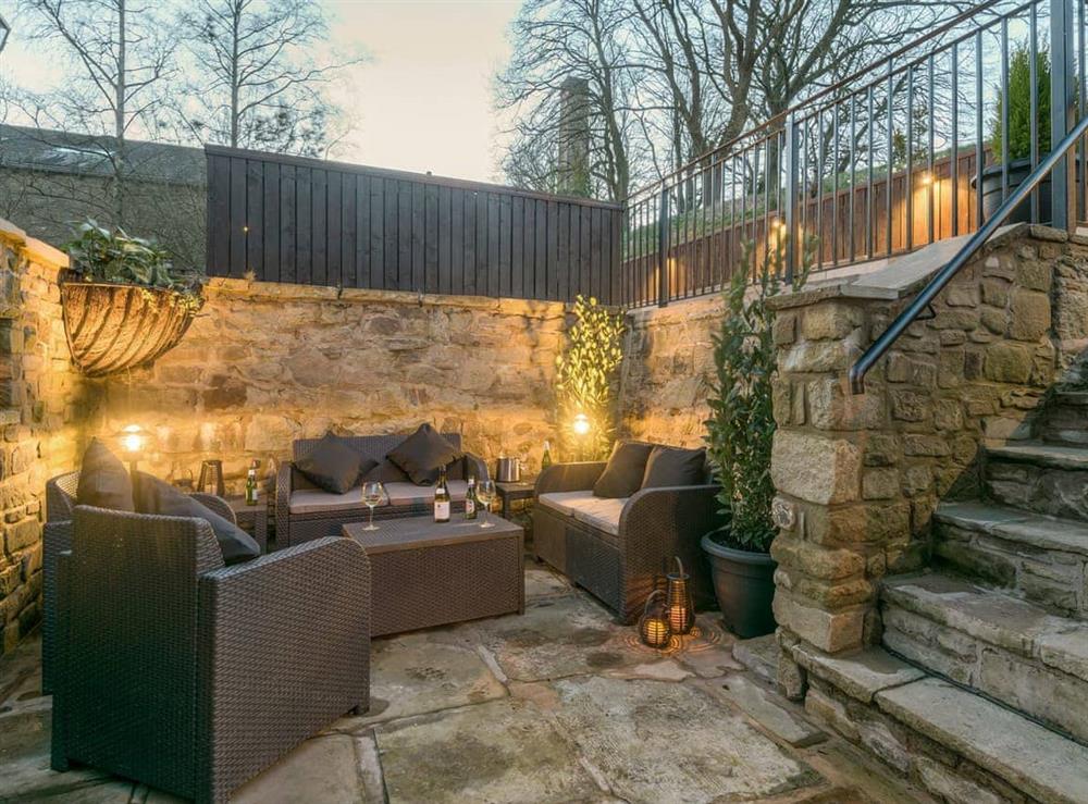 Sheltered area of patio illuminated for the evening at Narrowgates Cottage in Barley, near Barrowford, Lancashire, England