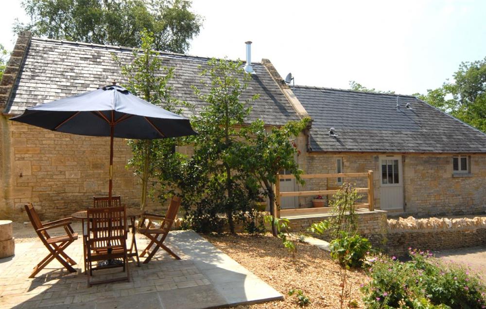 There is a patio area to the front of the barn with garden table and chairs and gas barbecue at Nellies Barn, Naunton