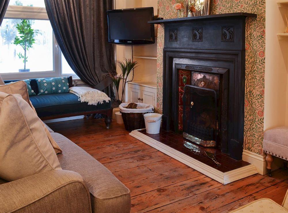Lovely wood-floored living area with open fire at Nells Cottage in Bridlington, North Humberside