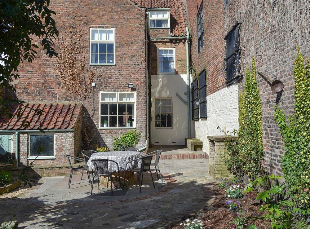 Private courtyard with table and chairs for al-fresco dining at Nells Cottage in Bridlington, North Humberside