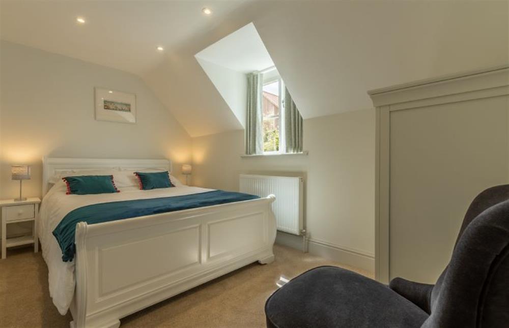 First floor: Master bedroom with king-size wooden sleigh bed at Neptune House, Wells-next-the-Sea