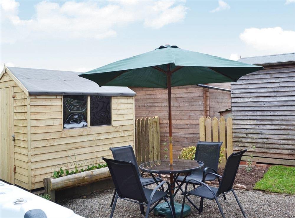 The decked area of the private garden has an outdoor eating area as well as the hot tub at The Barn, 