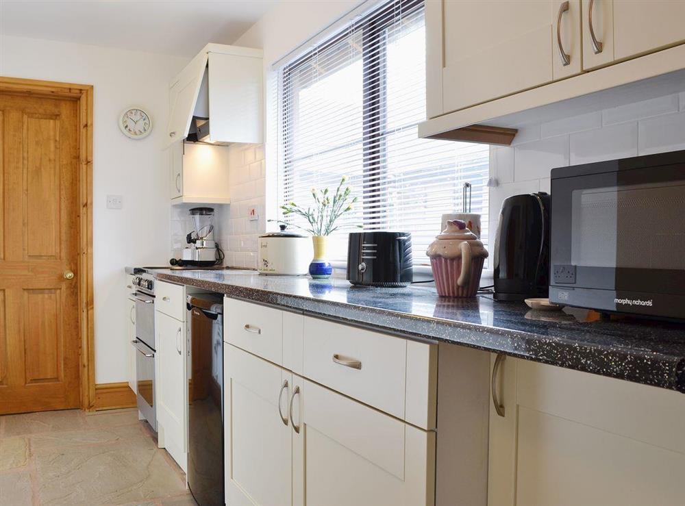 The kitchen has granite effect work tops and clean, modern units at The Barn, 