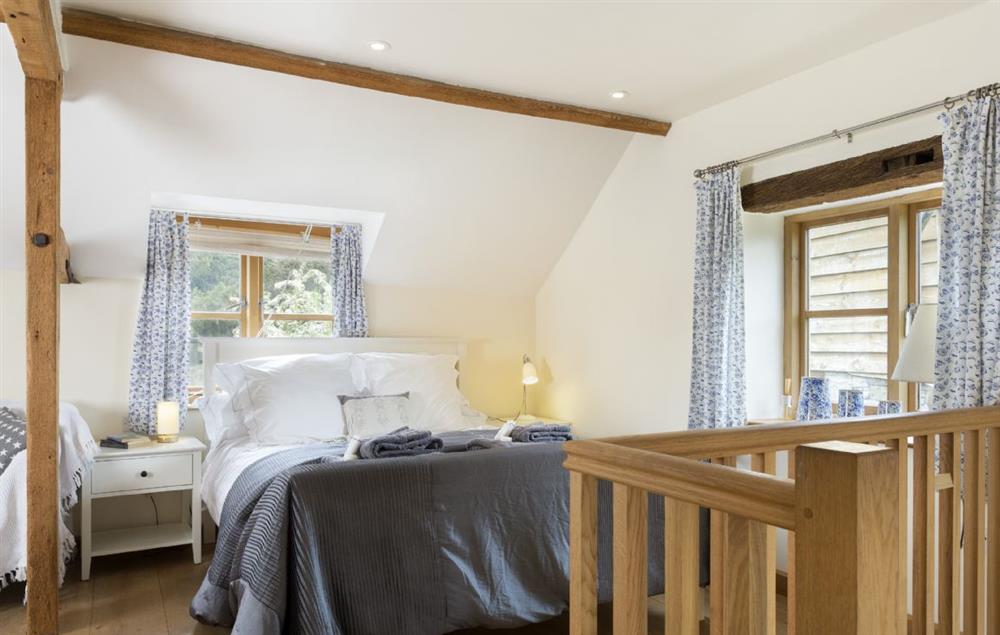 Galleried bedroom suite with a king-size bed,  sitting area and en-suite shower room at New Inn Cottage, Cardington