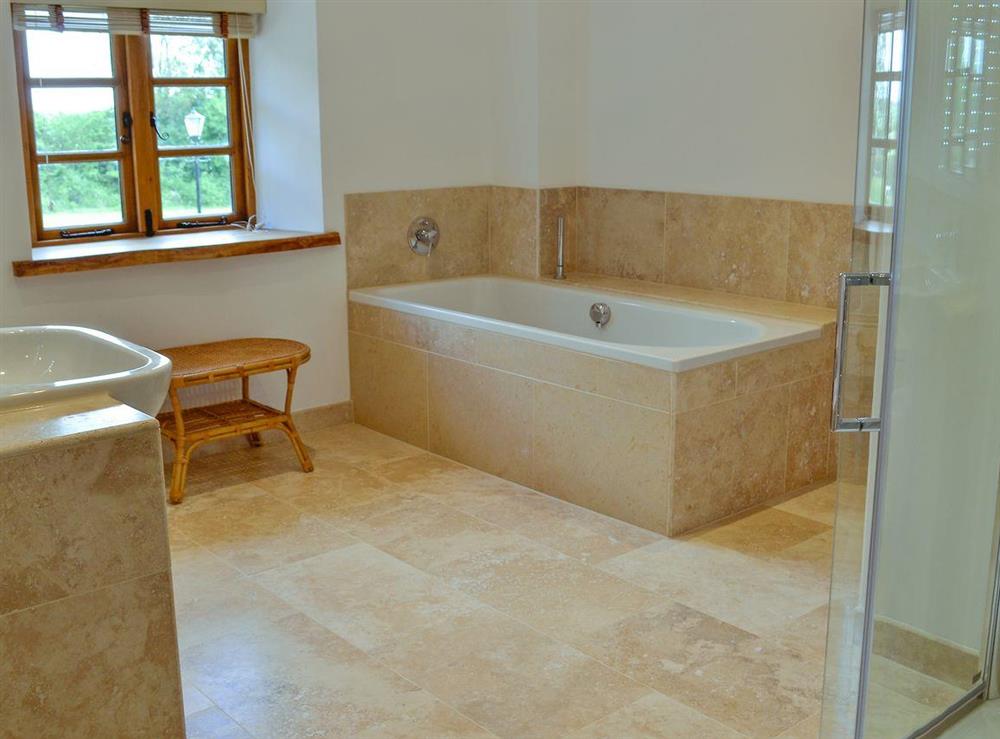 Bathroom with bath, shower cubicle, toilet, bidet, heated towel rail and tiled floor at New Inn Farmhouse in Marnhull, near Shaftesbury, Dorset