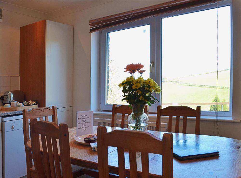 A farmhouse kitchen-style dining table with views out over the countryside at Anglers Rest, 