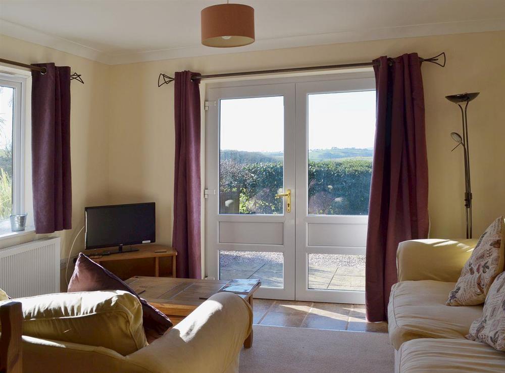 Relaxing living room with views out of the French doors across Dartmoor at Dartmoor View, 