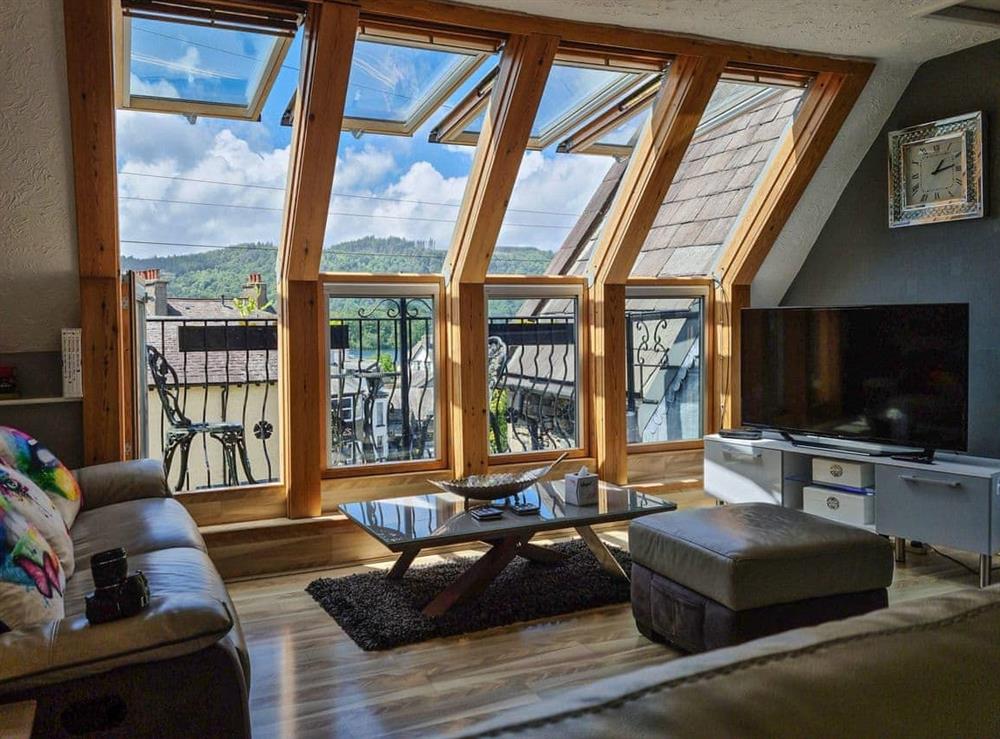 Living area with windows open to balcony at Newfold Cottage in Bowness-on-Windermere, Kirkcudbrightshire