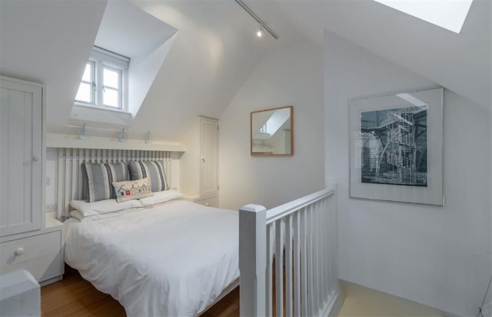 Bedroom area is divided by a short wall from the living area at Newgate Boathouse, Wells-next-the-Sea