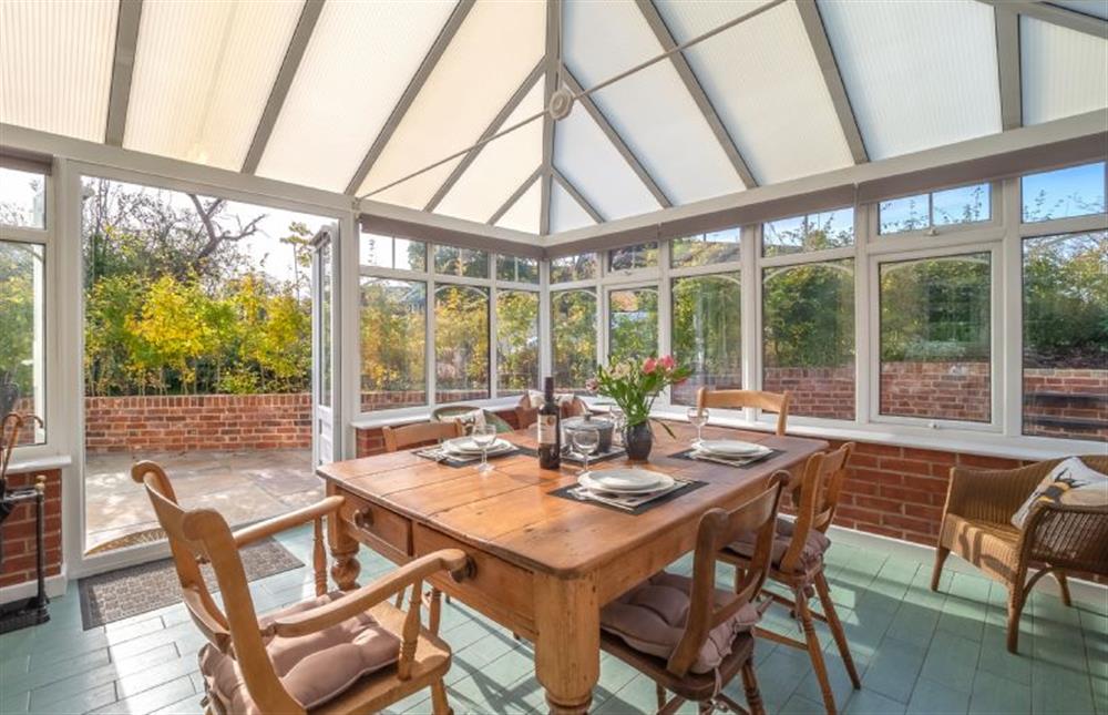 Conservatory with dining table and seating for six guests at No 2 The Anchorage, Sweffling