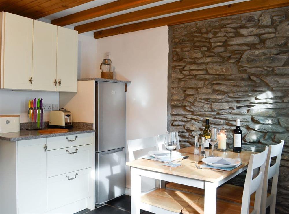 Dining area and adjacent kitchen at Noddfa Cottage in Llanfairtalhaiarn, near Abergele, Clwyd