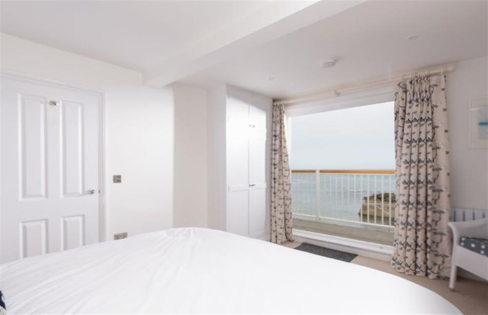 Bedroom one with triple folding glazed doors leading to the balcony at Northcliffe, Port Isaac