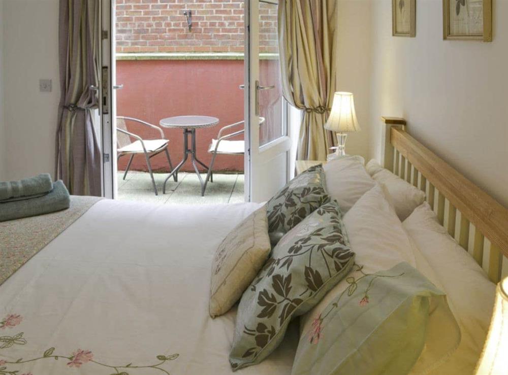 French doors in double bedroom lead to private terrace with outdoor furniture at Number 7 in Whitby, North Yorkshire