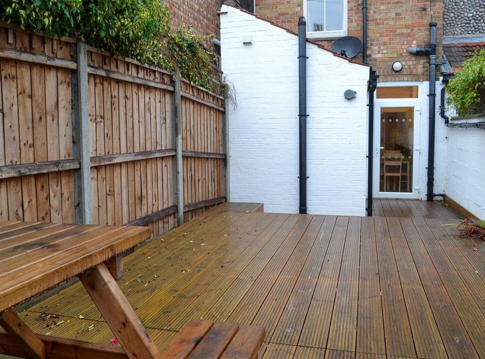 Enclosed courtyard garden with decking and garden furniture at Number 8 in Sheringham, Norfolk