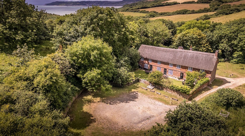 An aerial view of St Gabriels Cottages, their shared garden and parking spaces, Dorset at Oak Cottage in Bridport, Dorset