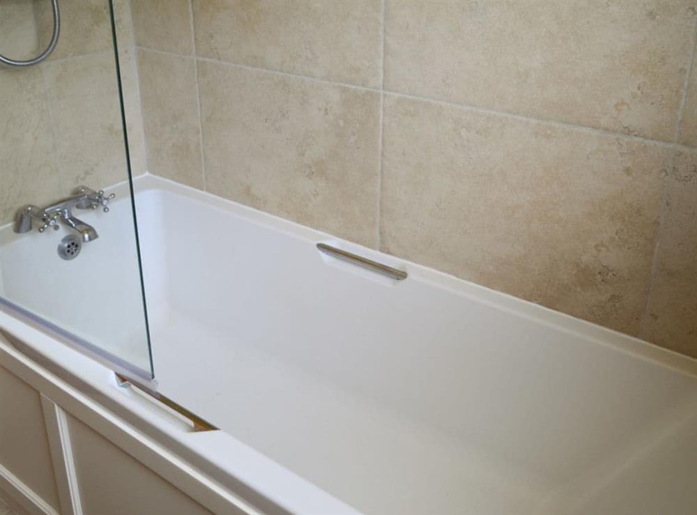 Shower over bath within family bathroom at Oakdene Lodge in Wimborne, Dorset
